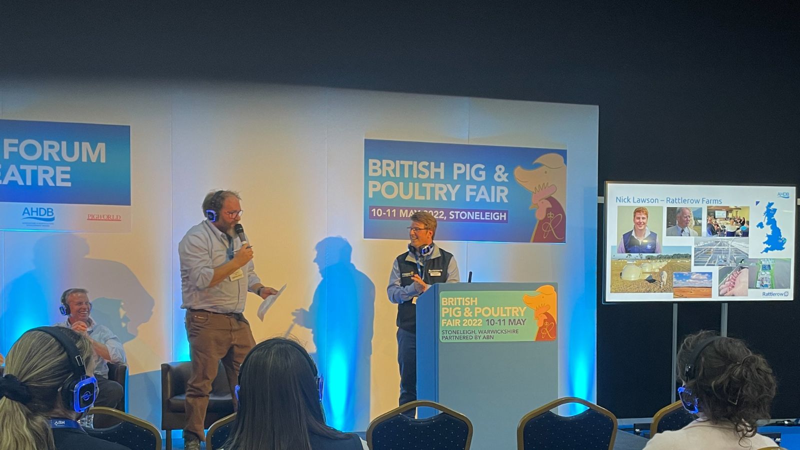 Izak Van Heerden and Nick Lawson discussing on the 2022 Britisg Pig and Poultry fair podium